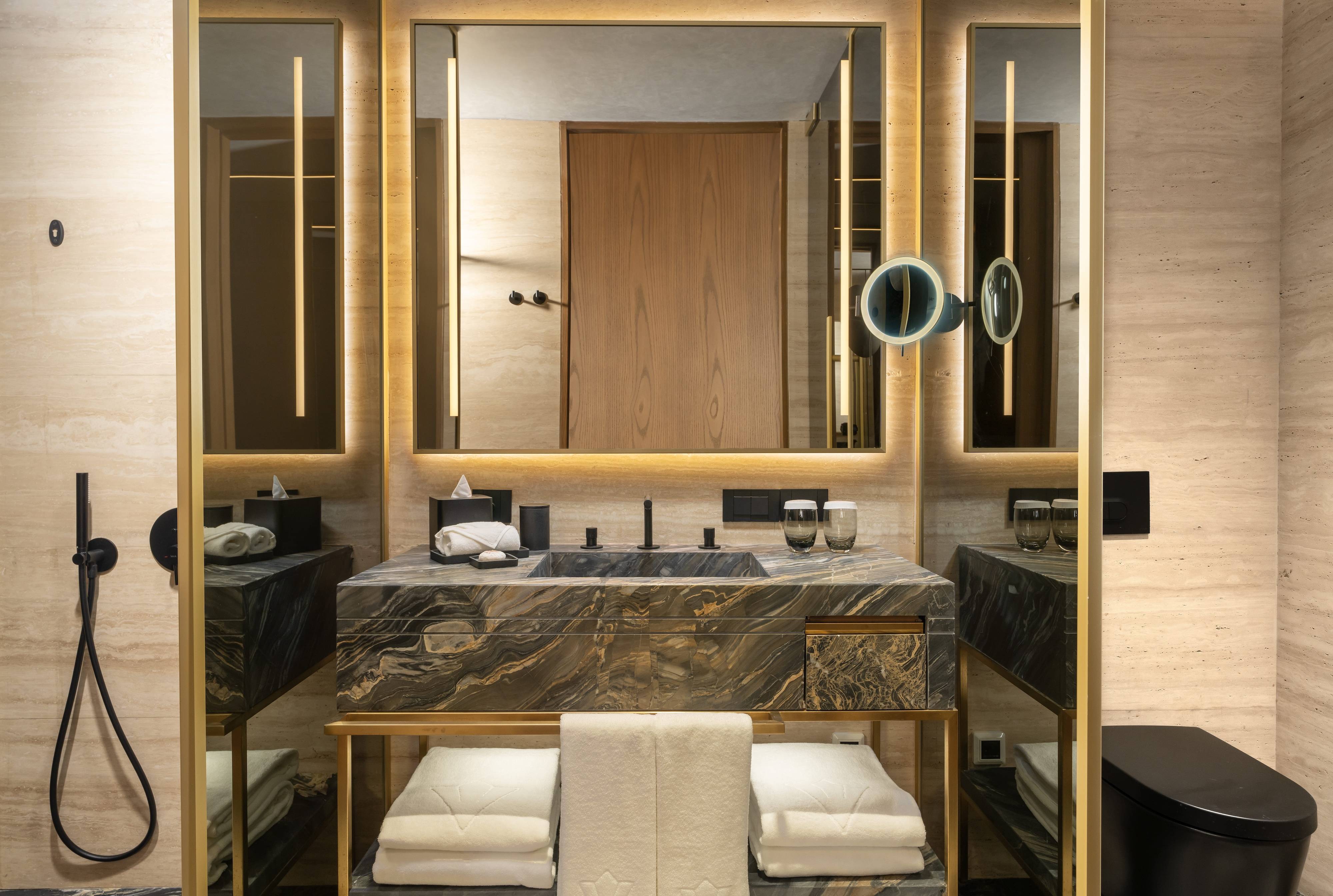 Elegancki pokój typu Premium z widokiem na morze i łóżkiem typu king-size w hotelu Rixos Tersane Istanbul oferuje nowoczesną łazienkę z marmurowym blatem, prysznicem ze strumieniem deszczowym i wbudowanym oświetleniem w neutralnej, wyrafinowanej palecie kolorów.