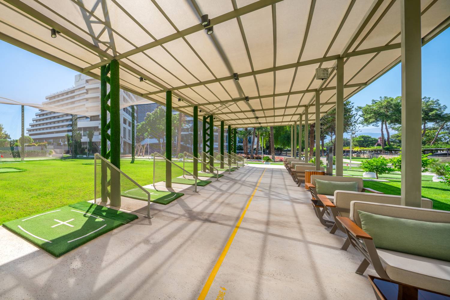 Natkriveni prostor za vježbanje na Rixos Golf Rangeu u Rixos Downtown Antalya s golf prostirkama i sjedalima