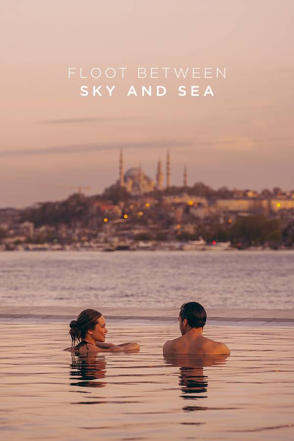 Para relaksująca się w basenie bez krawędzi w hotelu Rixos Tersane Istanbul o zachodzie słońca, z widokiem na Złoty Róg i historyczną panoramę miasta.