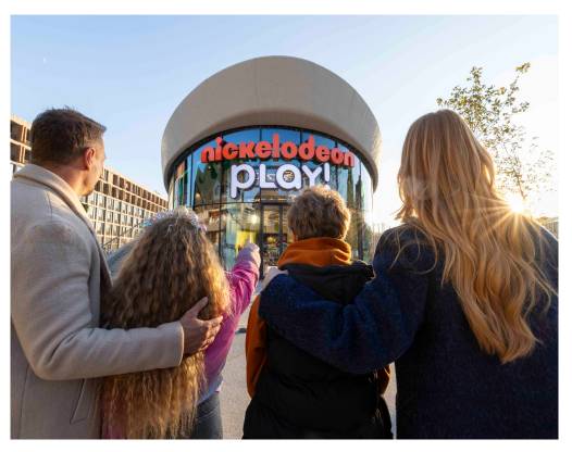 Une famille de quatre personnes se tient dos à la caméra, regardant vers le haut l'entrée ronde et vitrée du centre Nickelodeon Play! au Rixos Tersane Istanbul.