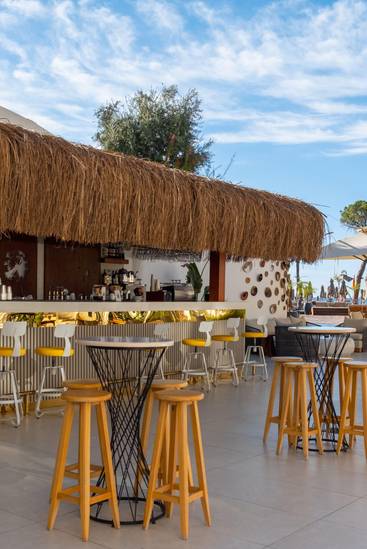 Outdoor Pool & Chill Bar at Rixos Park Belek featuring straw-roof design, bar stools, and sea-view terrace.